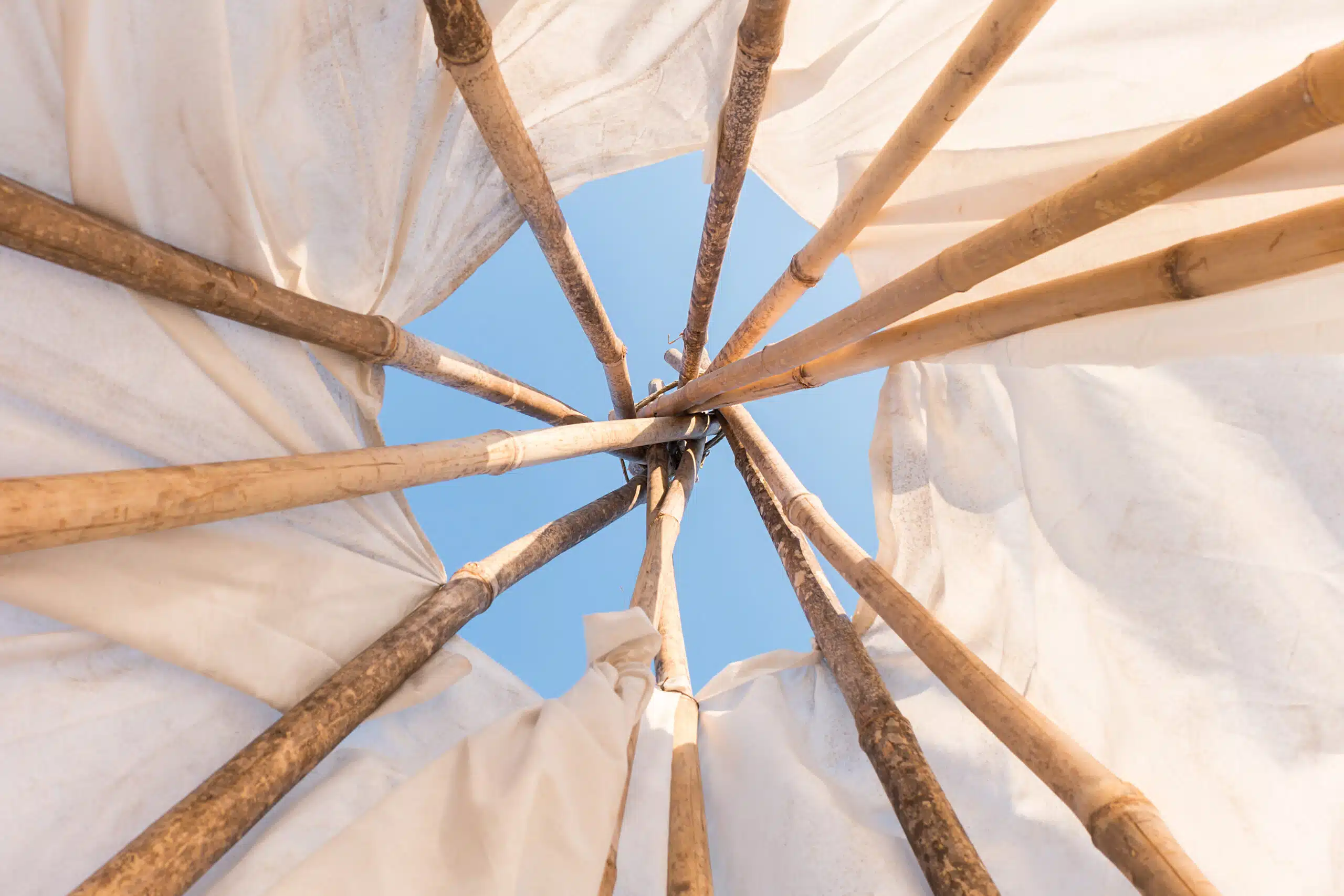 Interior structure of a tipi, looking up towards the apex where the poles are tied together.