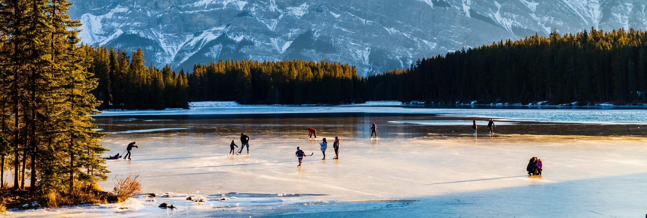 People ice-skating on the Two Jack Lake in Banff national park, Canada.