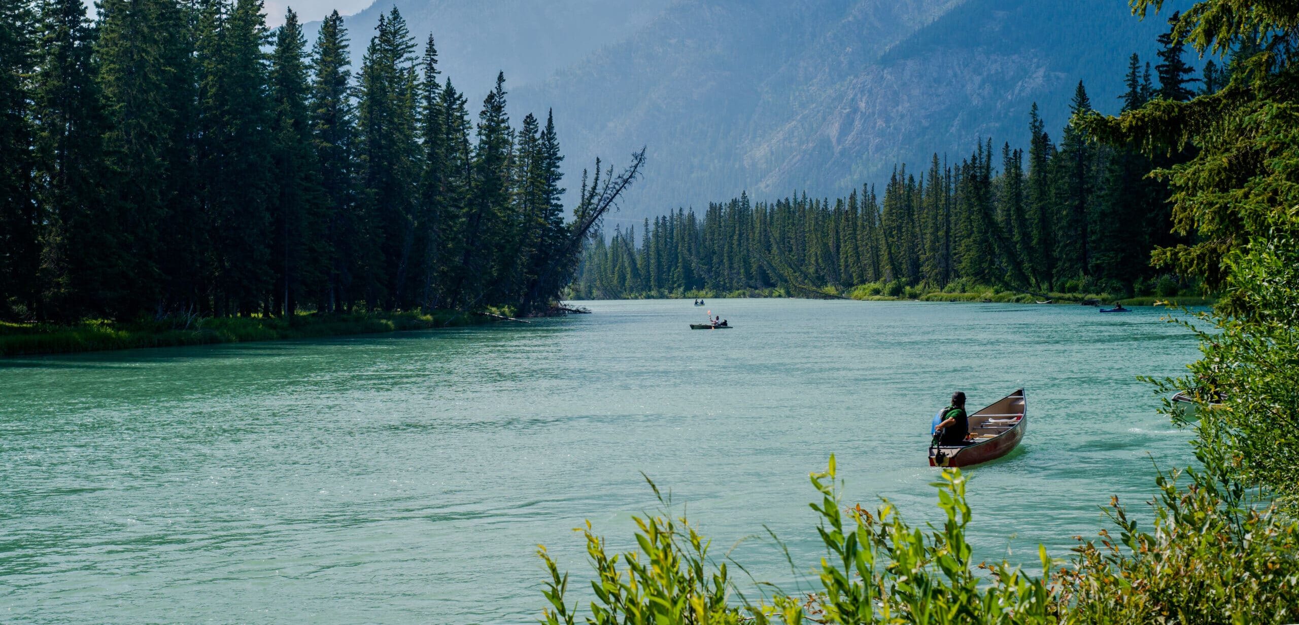 Landscape of a river with boats in Banff, Alberta.
