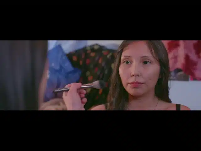 A girl helping her friend with her makeup.