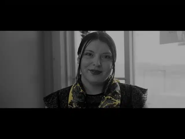 Human trafficking victim speaking in front of the camera.